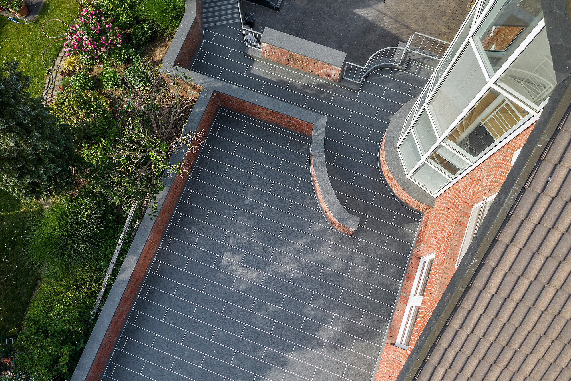 Terrassen- und Treppenabdichtung Drohnenbild einer fertigen Terrasse in Fliesenoptik.